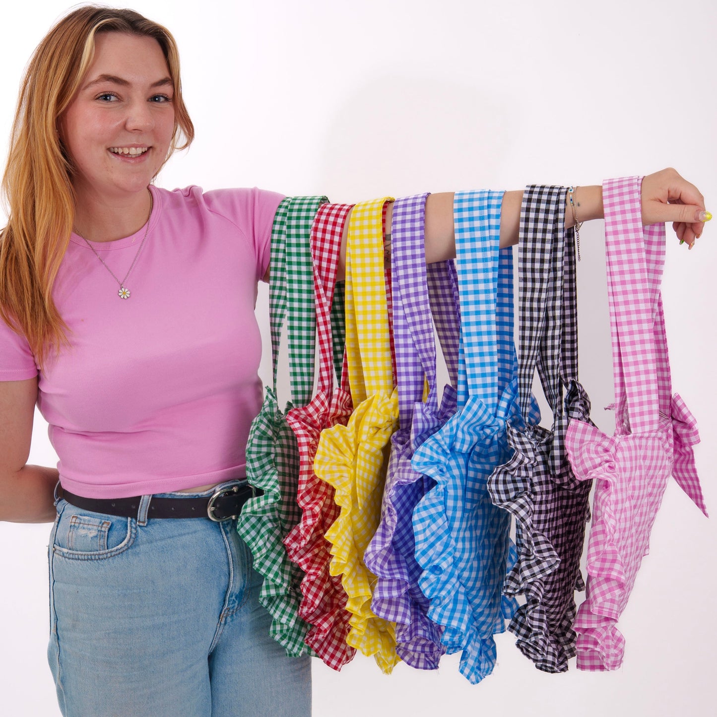 Woman holding up colorful checkered ribbons against a white background