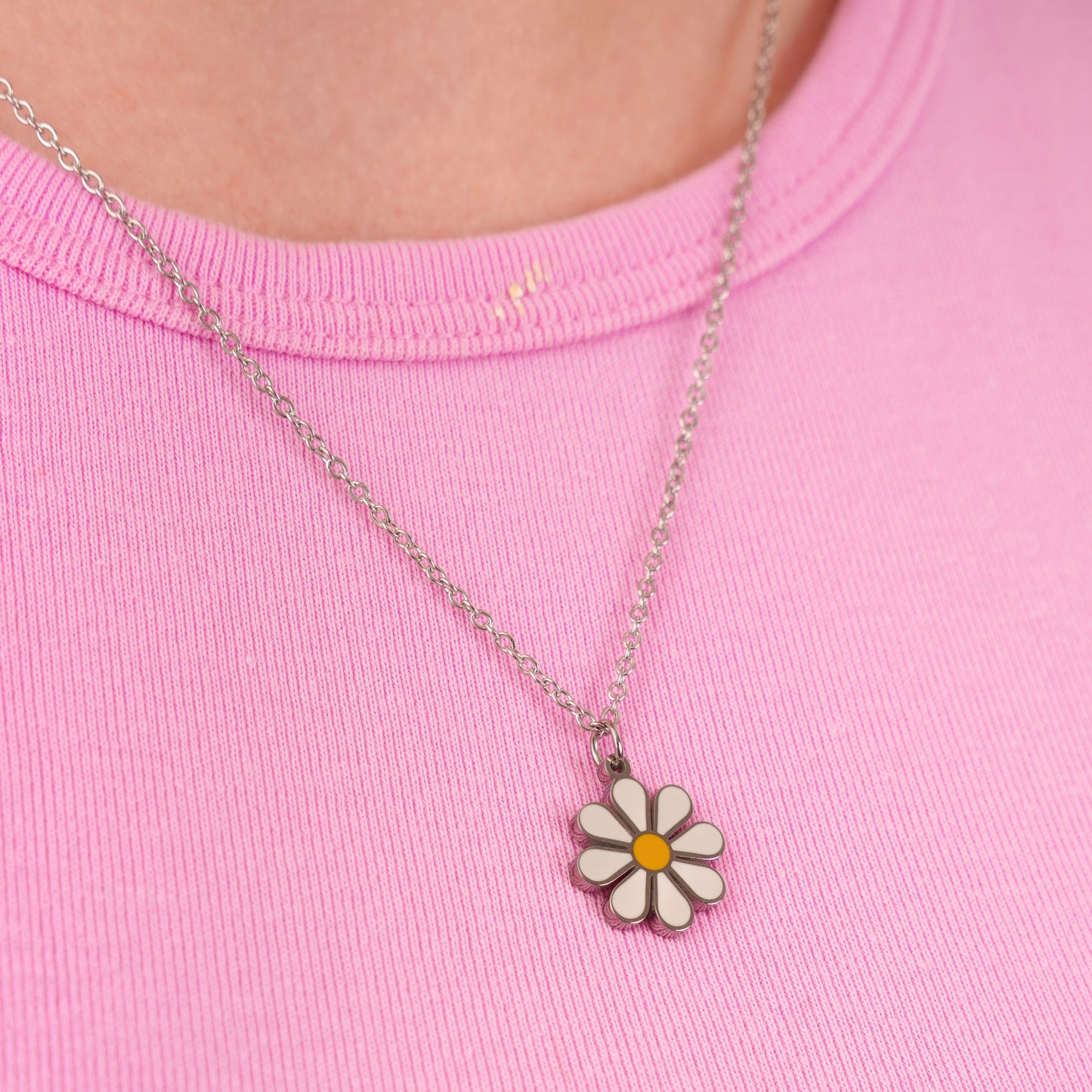 Necklace with a daisy pendant on a pink shirt
