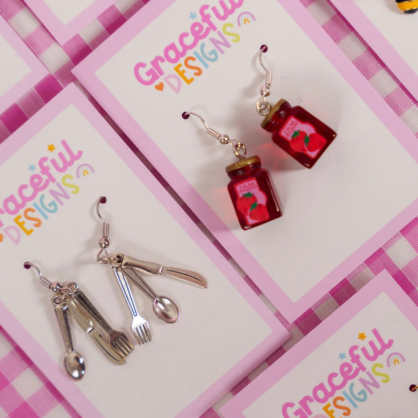 Earrings on a 'Graceful Designs' card with a pink checkered background