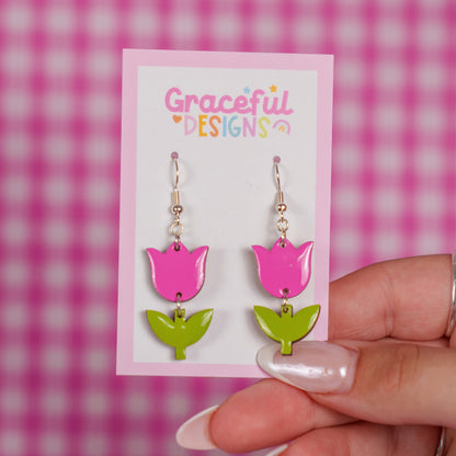 Pink and green tulip-shaped earrings on a 'Graceful Designs' card against a pink checkered background.