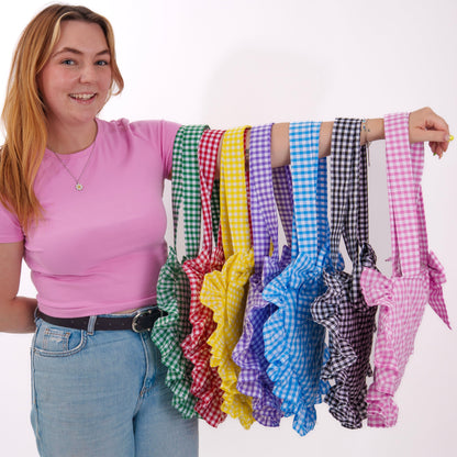 Woman holding up colorful checkered ribbons against a white background