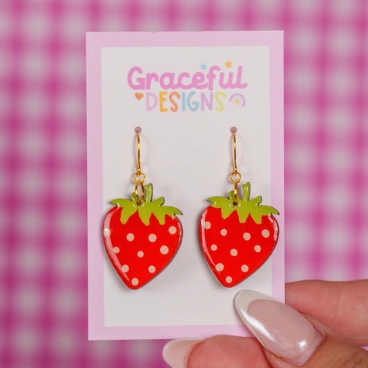 Strawberry-shaped earrings on a 'Graceful Designs' card against a pink and white checkered background.
