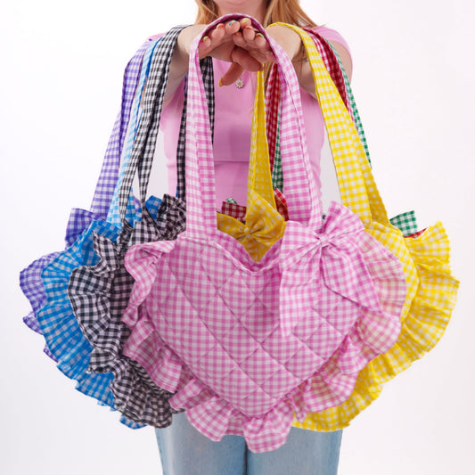 Person holding colorful gingham bags on a white background