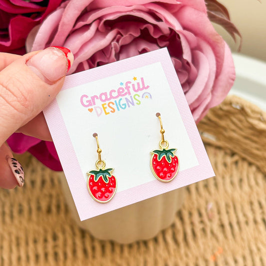 Strawberry-shaped earrings on a 'Graceful Designs' card with pink flowers in the background