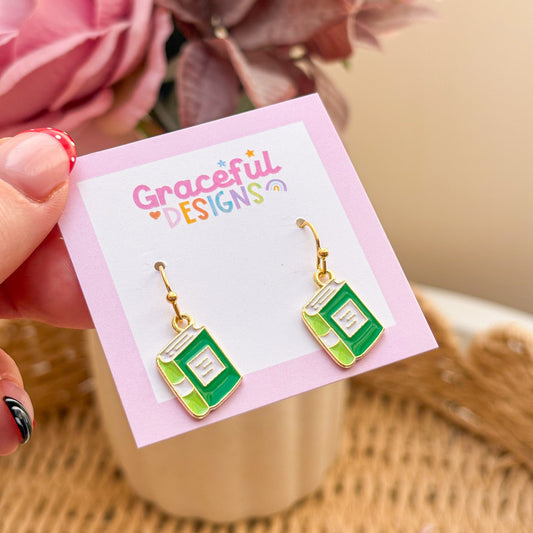 Book-shaped earrings on a 'Graceful Designs' card with flowers in the background
