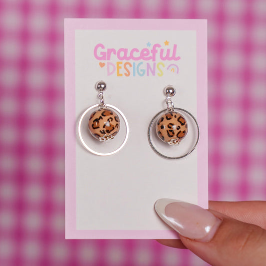 Leopard print earrings on a 'Graceful Designs' card with a pink checkered background