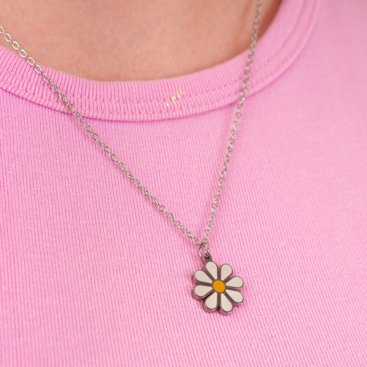 Necklace with a daisy pendant on a pink shirt