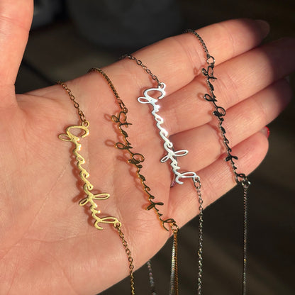 Hand holding multiple necklaces with 'Graceful' text in various colors.