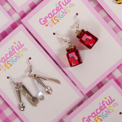 Earrings on a 'Graceful Designs' card with a pink checkered background