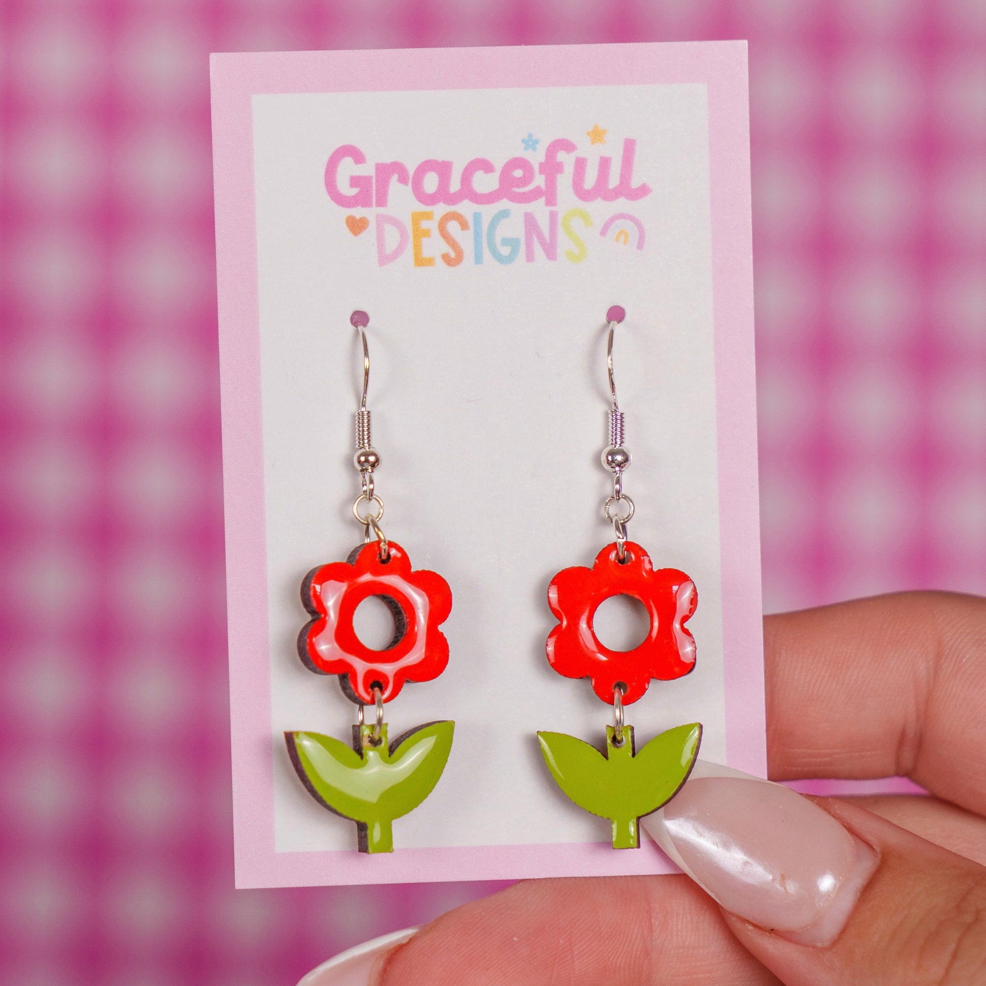 Red and green floral earrings on a 'Graceful Designs' card against a pink checkered background.