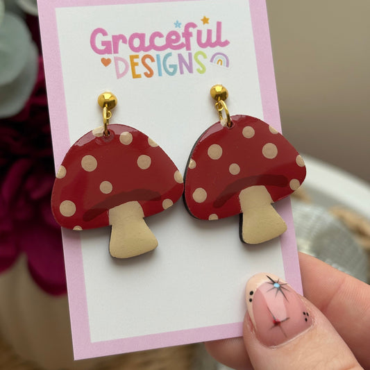 Red polka dot earrings on a 'Graceful Designs' card held by a hand.