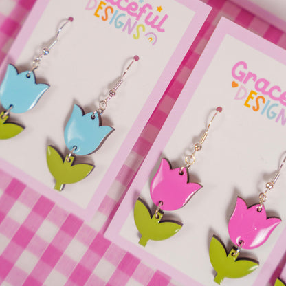 Colorful tulip-shaped earrings on 'Graceful Designs' cards with a pink checkered background.