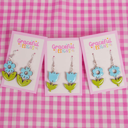 Floral earrings on cards with 'Graceful Designs' branding against a pink checkered background