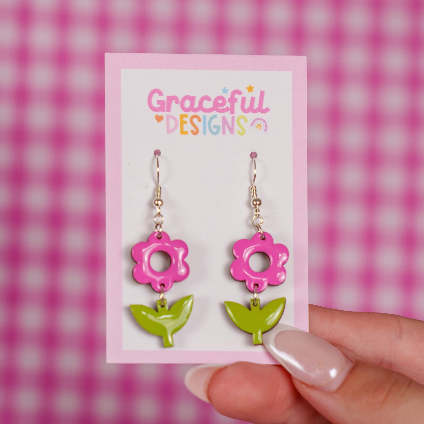 Pink and green floral earrings on a 'Graceful Designs' card against a pink checkered background.