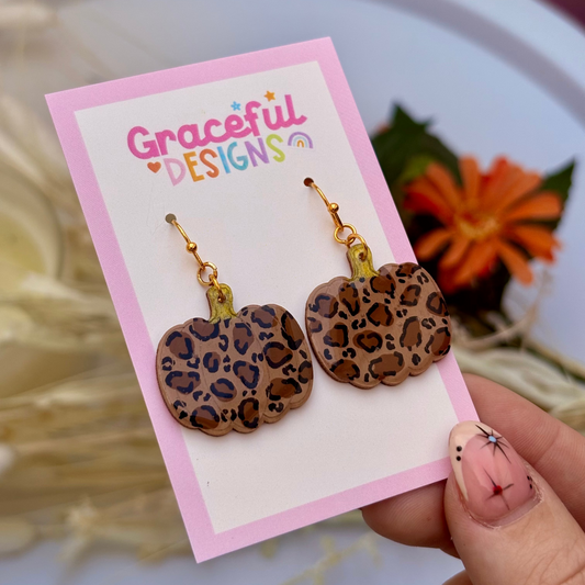 Leopard print earrings on a 'Graceful Designs' card with a blurred floral background